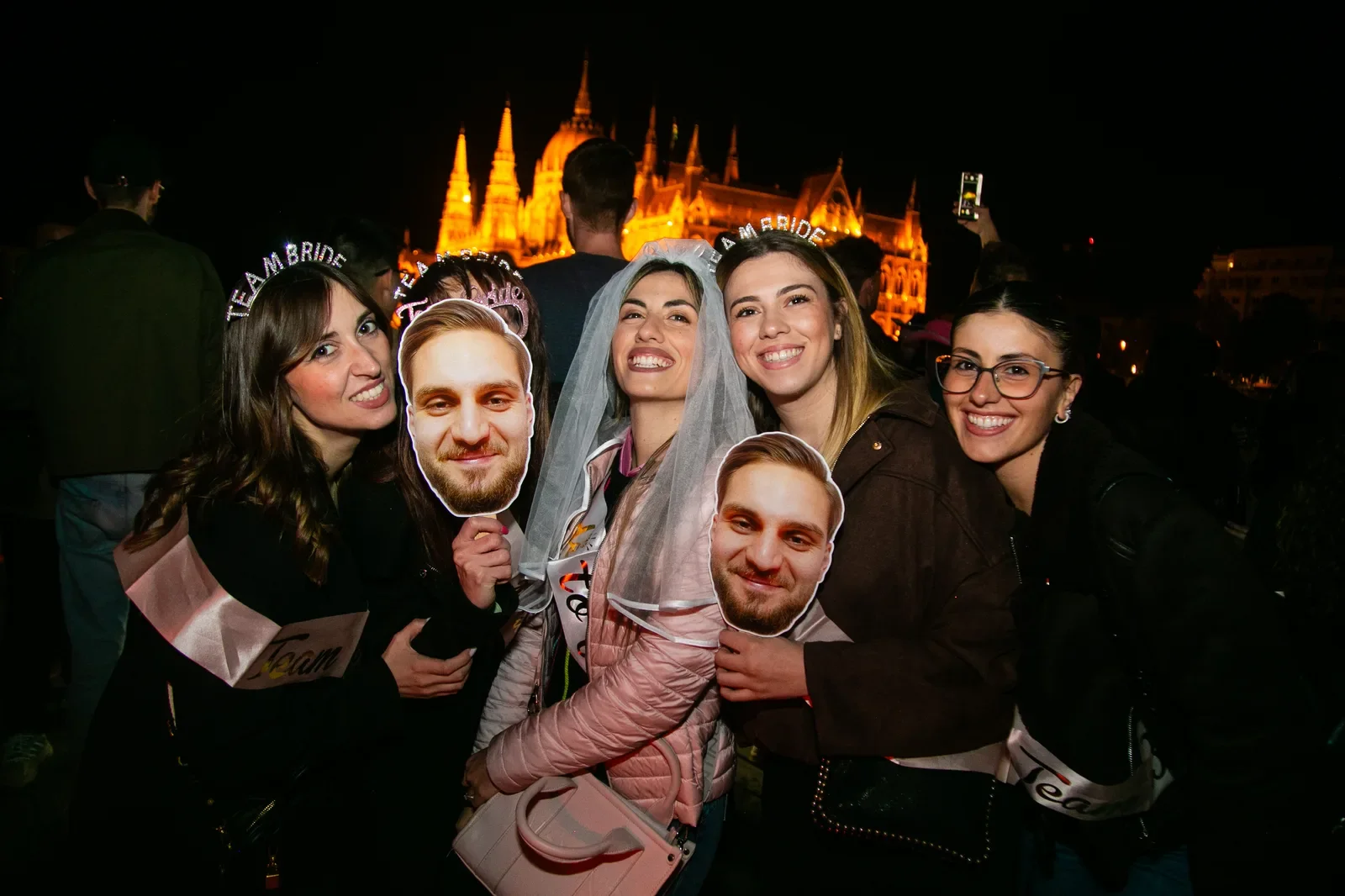 Group celebrating aboard a Budapest party boat with Parliament in the background
