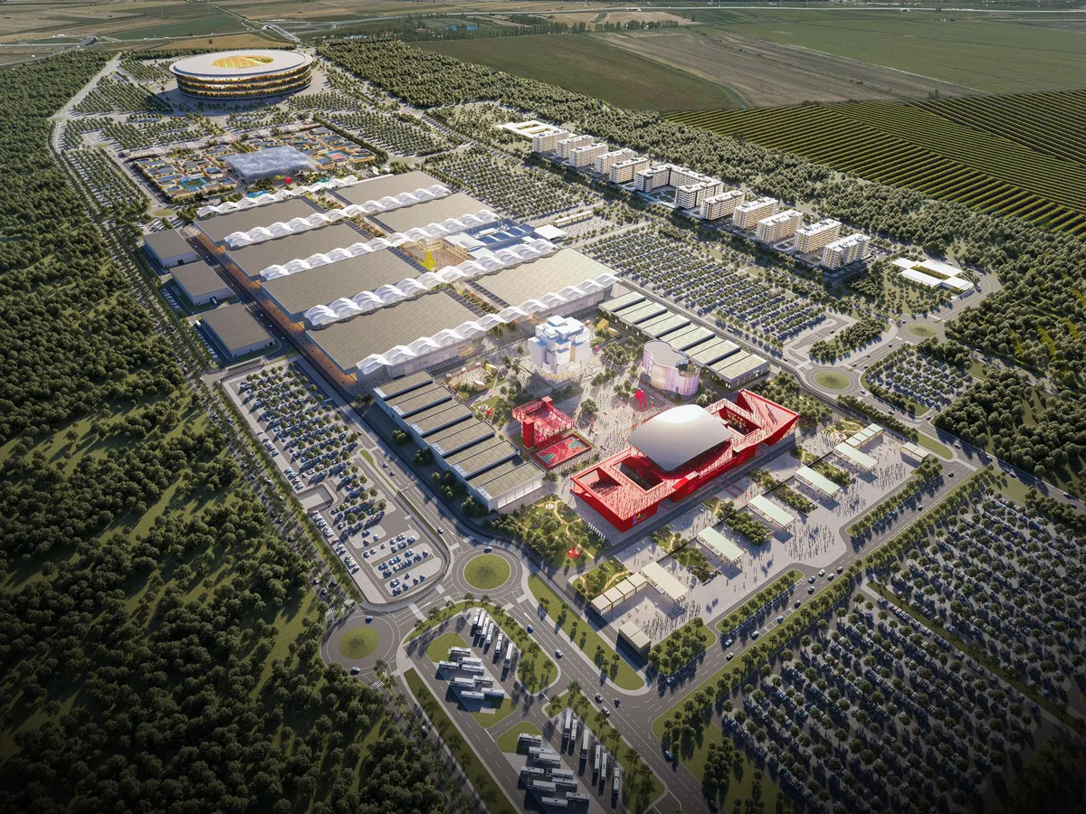 Aerial render of the Expo 2027 site in Surčin: long white-roofed exhibition halls, a red building with a white dome in front and the round National Stadium at the far end, surrounded by fields and woodland