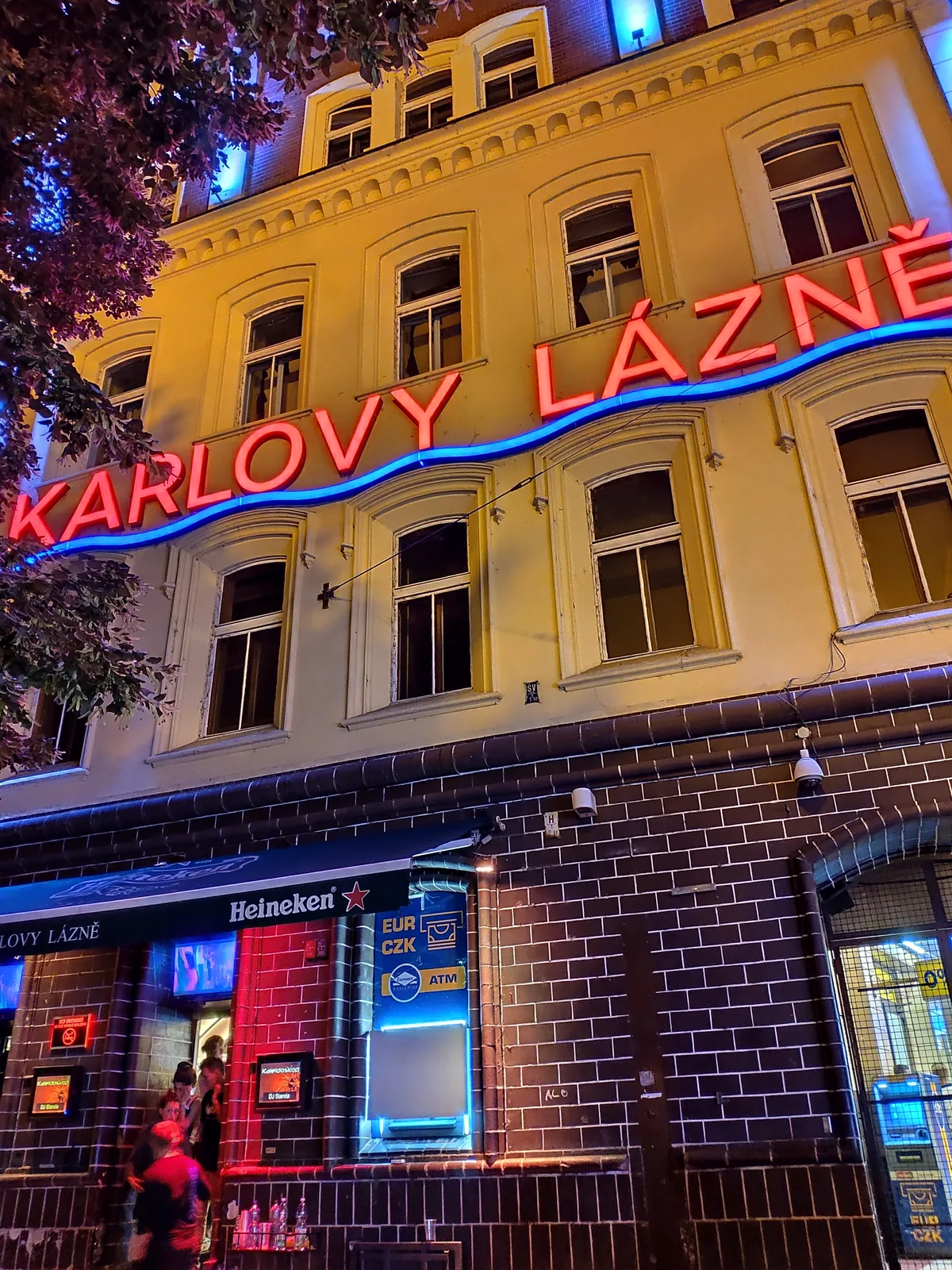 Neon Karlovy Lázně sign on the club building at night, Smetanovo nábřeží near Charles Bridge, Prague