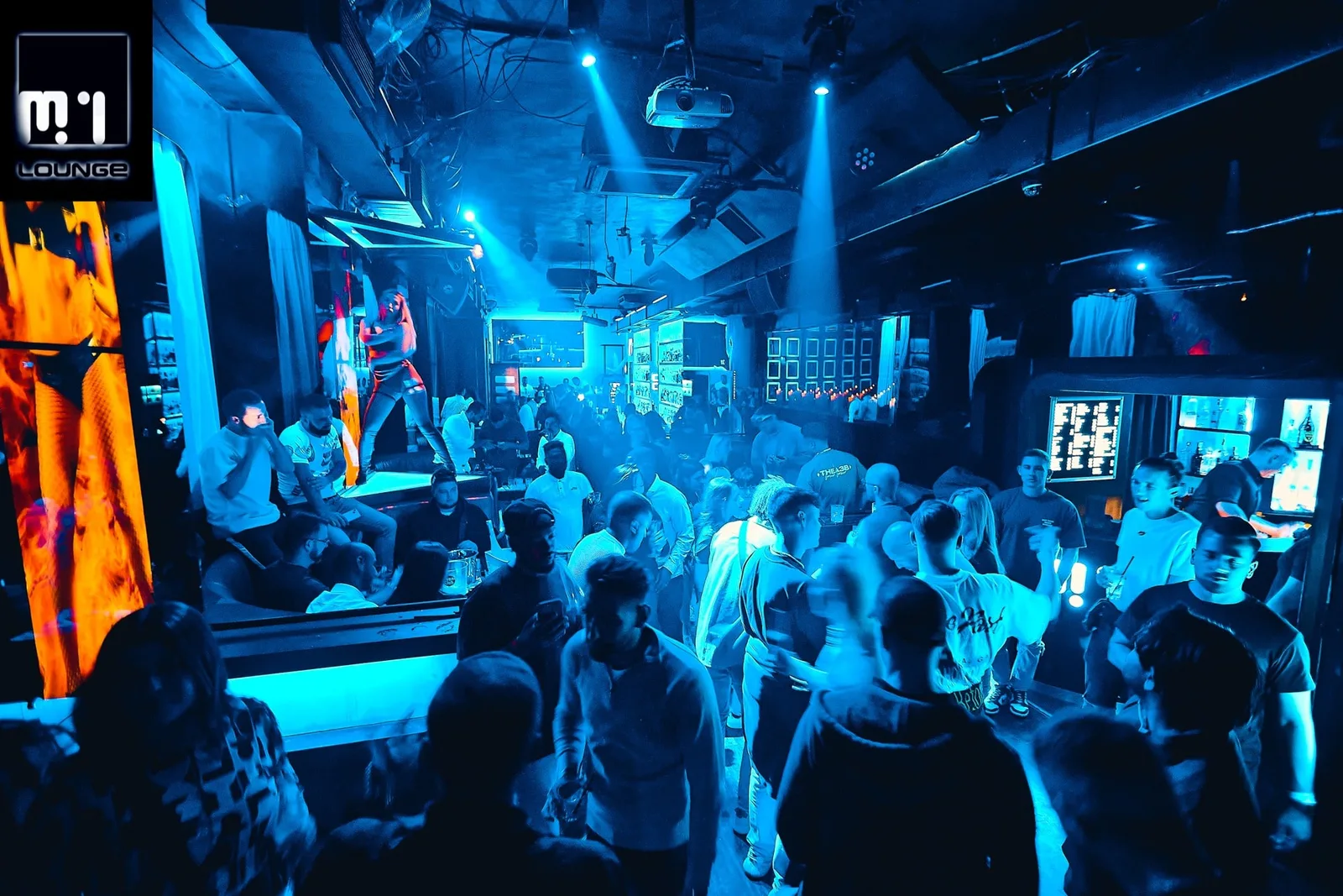 Crowd on the dance floor under blue lights at M1 Lounge, Masná street, Prague