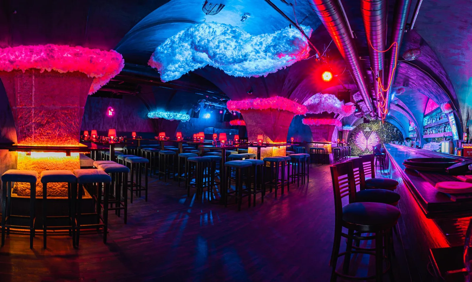 Vaulted main room with a long bar and neon-lit cloud ceiling at Nebe Cocktail Bar, V Celnici, Prague