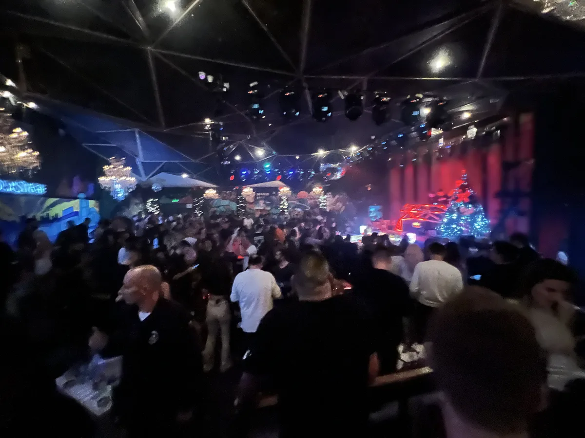 Crowd in a Belgrade club with red stage lights